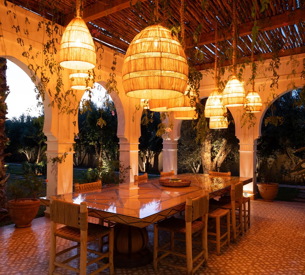 Salle à manger extérieure sous la pergola aux lanternes