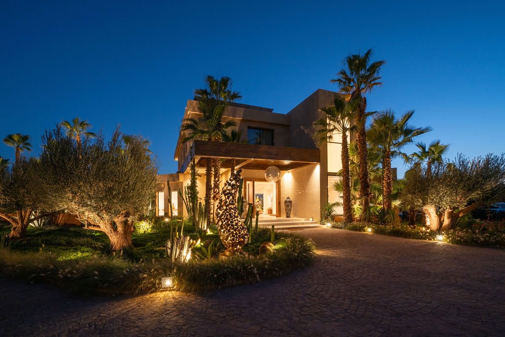 Façade de la villa illuminée à la nuit tombée