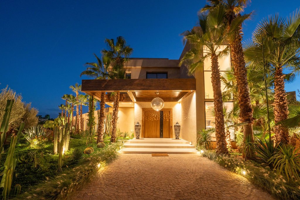 Façade de la villa illuminée à la nuit tombée