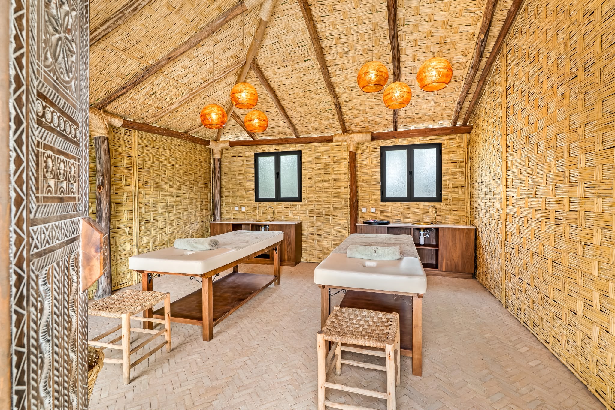 Salle de massage double sous une cabane en roseau