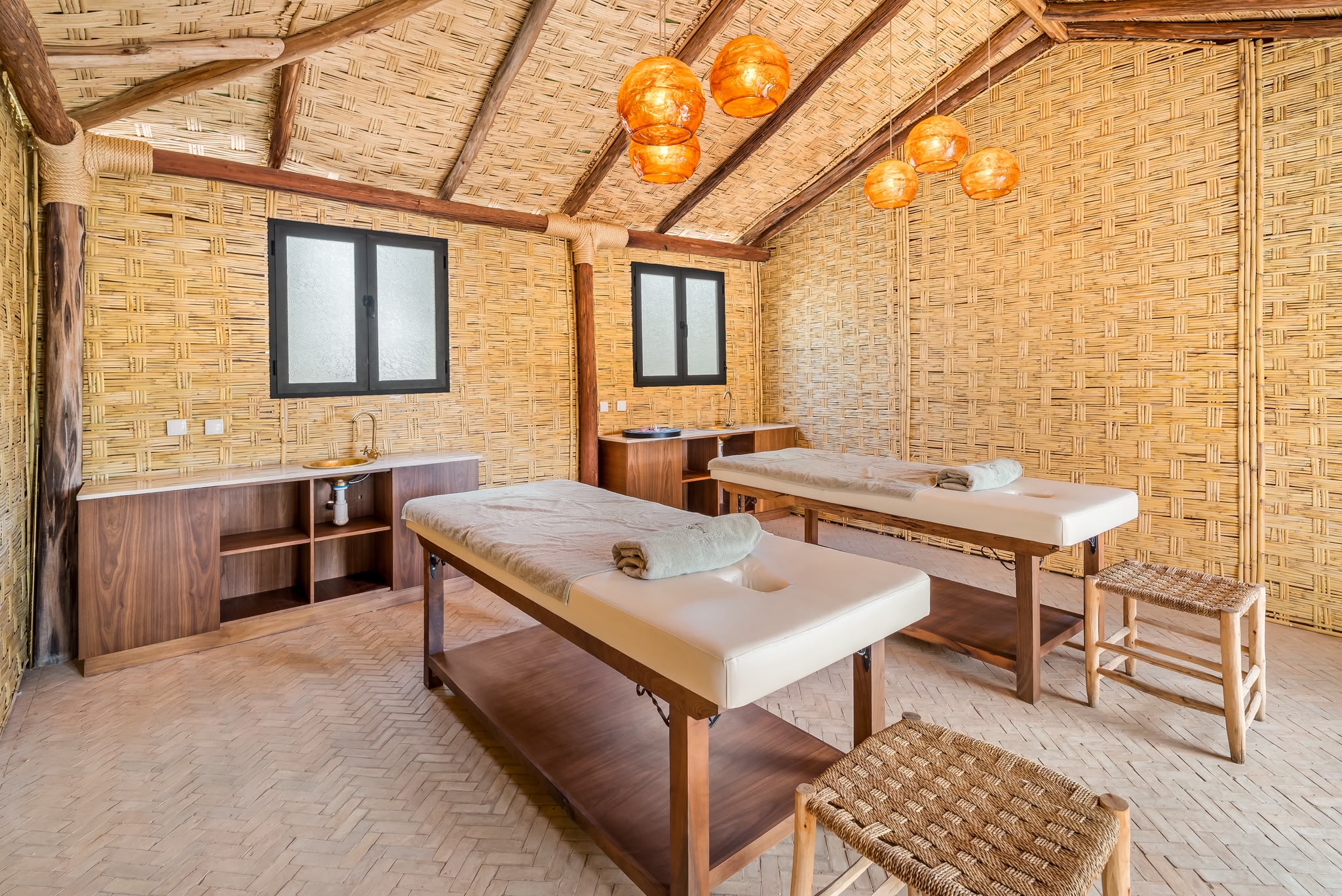 Salle de massage double sous une cabane en roseau