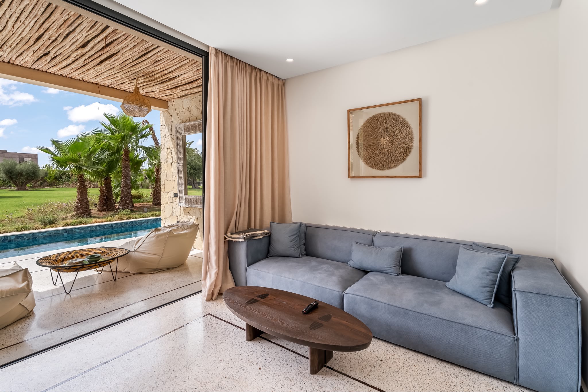 Salon et terrasse d’un pavillon, ouverts sur la piscine
