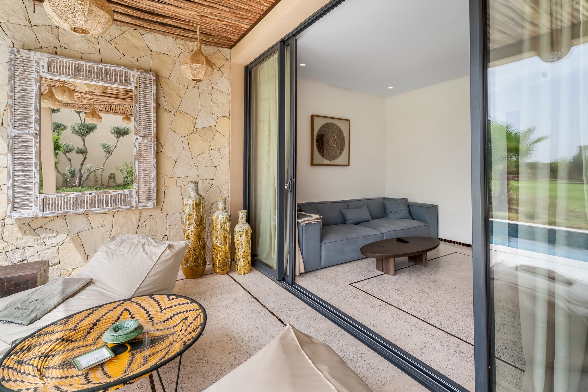Salon et terrasse d’un pavillon, ouverts sur la piscine